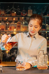  Professional female bartender preparing alcoholic drinks in a bar