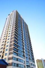 Fototapeta premium A very tall building featuring numerous windows set against a clear blue sky