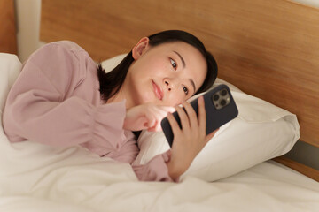 夜ベッドでスマホを使う女性