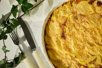 Deliciously baked gratin with golden crust served on a white rustic table