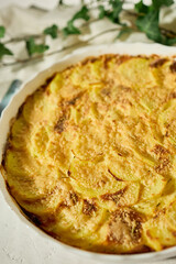 Deliciously baked gratin with golden crust served on a white rustic table