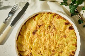 Deliciously baked gratin with golden crust served on a white rustic table