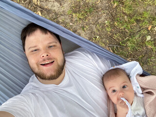 Father and Baby Relaxing in Hammock Outdoors