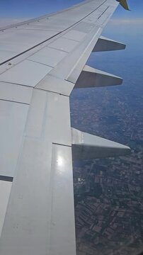 Aircraft flying again over patchwork farmland. Plane cruising high above fields and countryside. Jet soaring across rural landscape with scattered agricultural plots