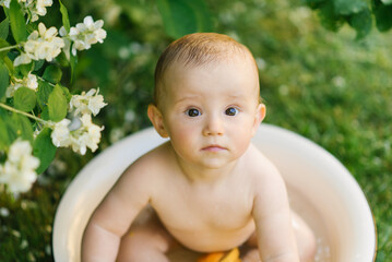 Baby Sitting In Water With Oranges And Flowers