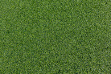 Detailed view of fake grass surface. Even green texture of artificial lawn, often used in sports...