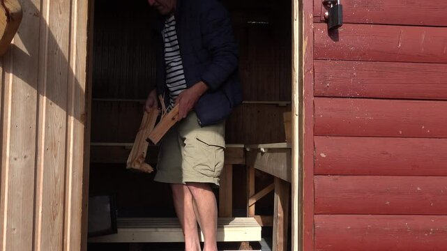 Stockholm, Sweden A man uses firewood to light a wood-fired sauna. 