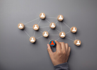 human resource manager hand holding icon to select one employee for leadership service and strong...