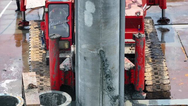 aerial view of the process of installing a giant sea wall by a large drilling machine on the north coast of Java Island