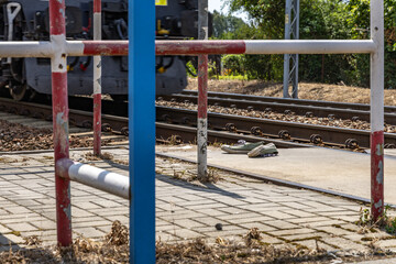 Accident scene on the tracks, train passing through an unguarded railway crossing, pedestrian hit on the tracks, shoes by the tracks