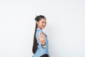 Young Southeast Asian woman wearing blue striped long sleeves smiles playfully while extending her...