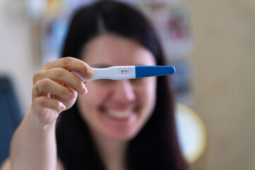Surprised Woman with Positive Pregnancy Test