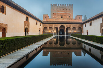 Fototapeta premium Comares Palace and its perfect reflection in the calm water of the pond, Nasrid palaces of the Alhambra, Granada, Andalusia.
