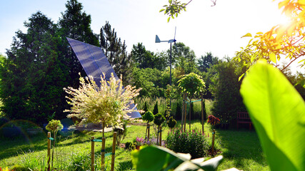 Solar panels with wind turbine on blue sky. Concept of clean energy. Green technology for future. 