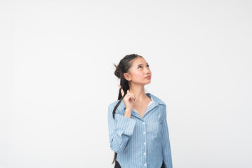 Young Southeast Asian woman in blue striped long sleeves twirls her hair while looking up...