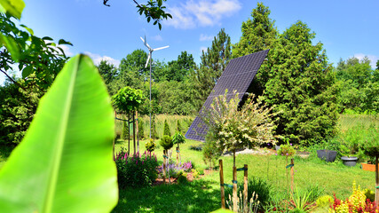 Solar panels with wind turbine on blue sky. Concept of clean energy. Green technology for future. 