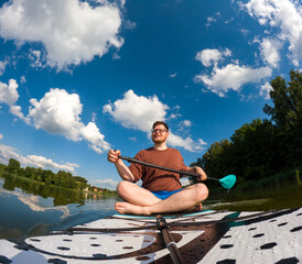 Man Taking Selfie on Paddleboard in Scenic Lake
