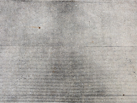 A horizontal abstract close-up of a concrete surface featuring straight etched lines. The rough texture and linear composition create a minimalist, industrial aesthetic.