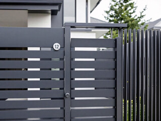 A modern outdoor space featuring a sleek, gray fence with horizontal slats for privacy and style.