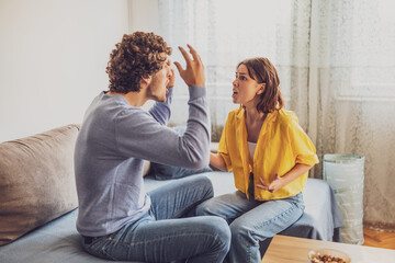 Naklejka premium Man and woman are sitting at sofa and arguing. Relationship problems.