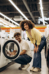 Smiling Couple Shopping for a Washer in an Electronics Store