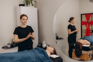 Professional Massage Therapist Preparing Spa Service for a Relaxed Client in a Modern Clinic