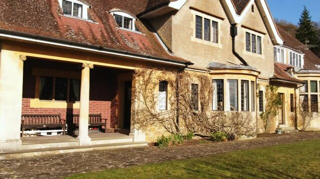 Wide shot pan of Fintry Mansion in Surrey hills during warm summer day.