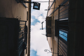 Looking Up Between Narrow Buildings with Hanging Laundry in Ortigia, Sicily