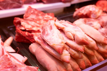 Raw pig feet on counter of butcher shop.