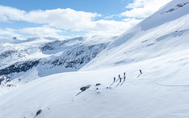 Alpine skiers in mountain. Group of downhill skiers on a slope on a bright sunny day. Norwegians mountains.