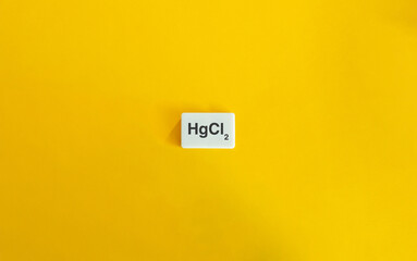 HgCl₂ (Mercuric Chloride) displayed on a wide white letter tile set against a vibrant yellow background.