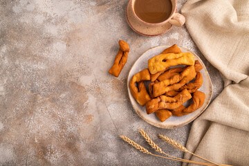 Crunchy biscuit Brushwood cookies on brown concrete, linen textile, cup of coffee, top view, flat...