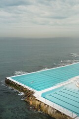Fototapeta premium Iconic Bondi Beach pool, Sydney, Australia. Ocean views, swimmers, and vibrant coastal scenery. Perfect for travel and lifestyle themes.