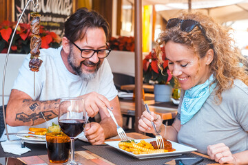 Happy couple enjoying meal at restaurant – romantic date, vacation mood, weekend vibes, relationship and quality time concept