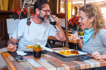 Happy couple enjoying meal at restaurant – romantic date, vacation mood, weekend vibes, relationship and quality time concept