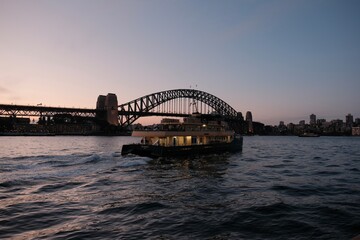 Sydney, Australia - August 10th 2024 - The iconic Sydney Harbour Bridge frames a cruising vessel....