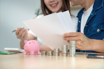 Financial Planning and Budgeting. Young couple discussing savings and investments with piggy bank.