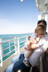 A man and a boy on a white boat in the sea are sitting by the side, father and son are enjoying a sea trip