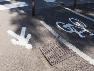 Pedestrian walkway and bike path markings separating traffic lanes in historic Bologna, highlighting urban infrastructure design