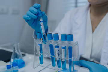 a female scientist is working in lab, a chemist tests liquid sample in science laboratory, she...