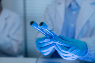 when in a lab, scientists wear lab coats, rubber gloves, and safety goggles, two chemists are testing chemicals in a liquid state, chemists working in a laboratory