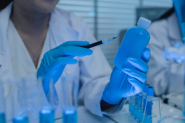 a female chemist is testing various liquid compounds in a lab, a scientist is doing research on the...