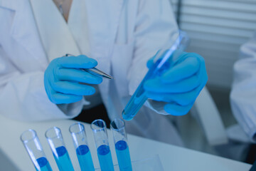 a female chemist is testing various liquid compounds in a lab, a scientist is doing research on the...