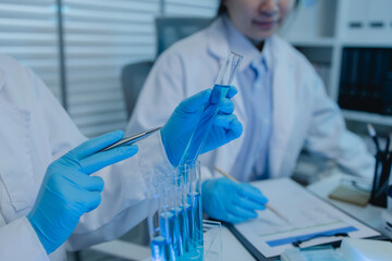 a female chemist is testing various liquid compounds in a lab, a scientist is doing research on the...