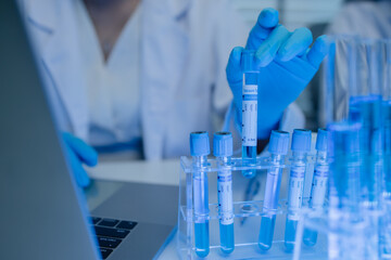 two scientists consult each other while conducting an experiment on a liquid substance in a...