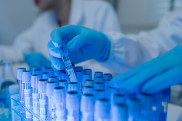 a female chemist is testing various liquid compounds in a lab, a scientist is doing research on the...