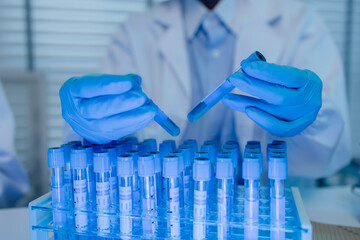 a female chemist is testing various liquid compounds in a lab, a scientist is doing research on the...
