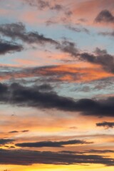 The sky is filled with clouds and the sun is setting. Phone wallpaper. Vertical background.