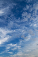 Cumulus and cirrus clouds on blue sky.