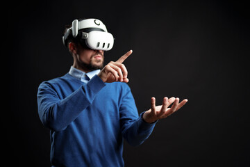 Virtual reality experience with a man interacting in a dark setting using advanced technology